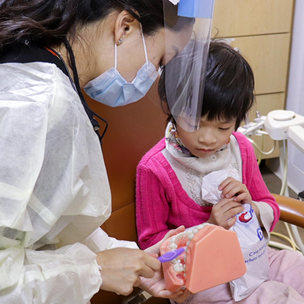 hygenist giving oral health education to child@2x