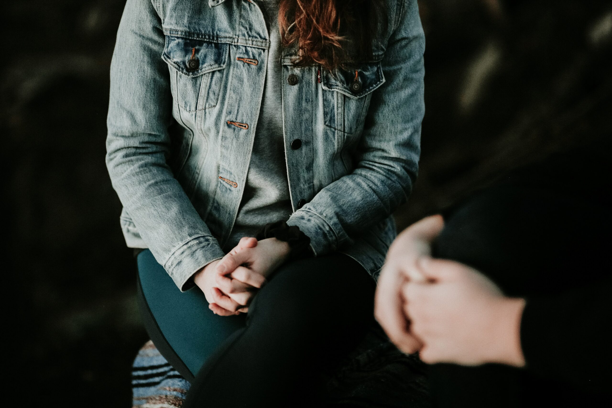 two pepole talking with hands folded